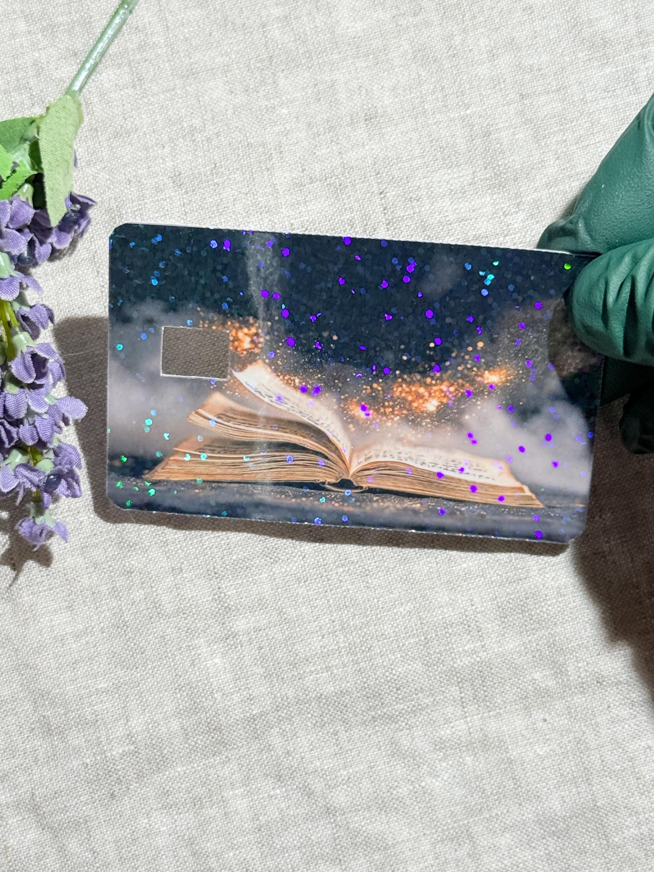 Magic book card skin on a debit card in a wallet by The Sticker Era