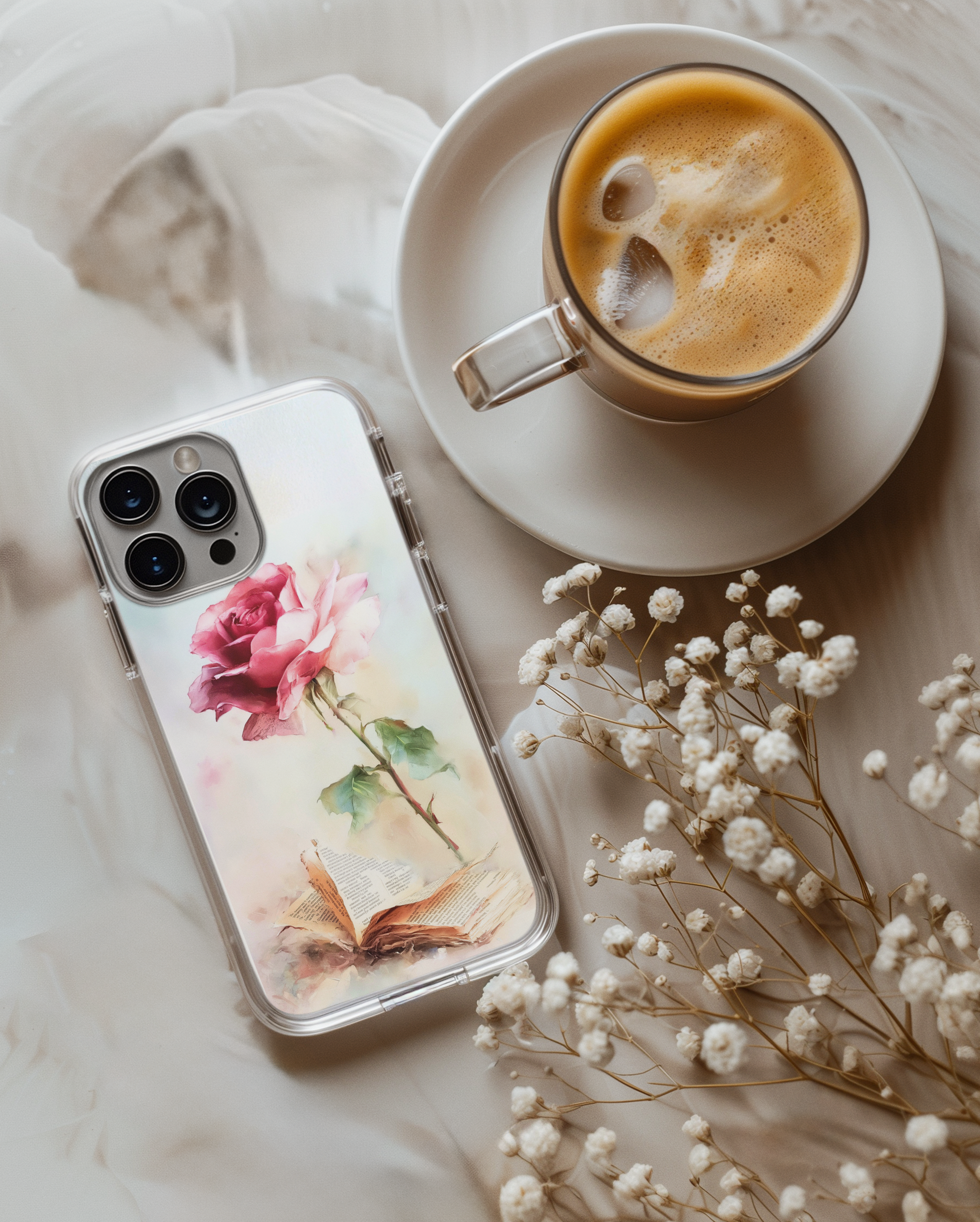 Phone case with floral design next to a cup of coffee and flowers on a soft surface