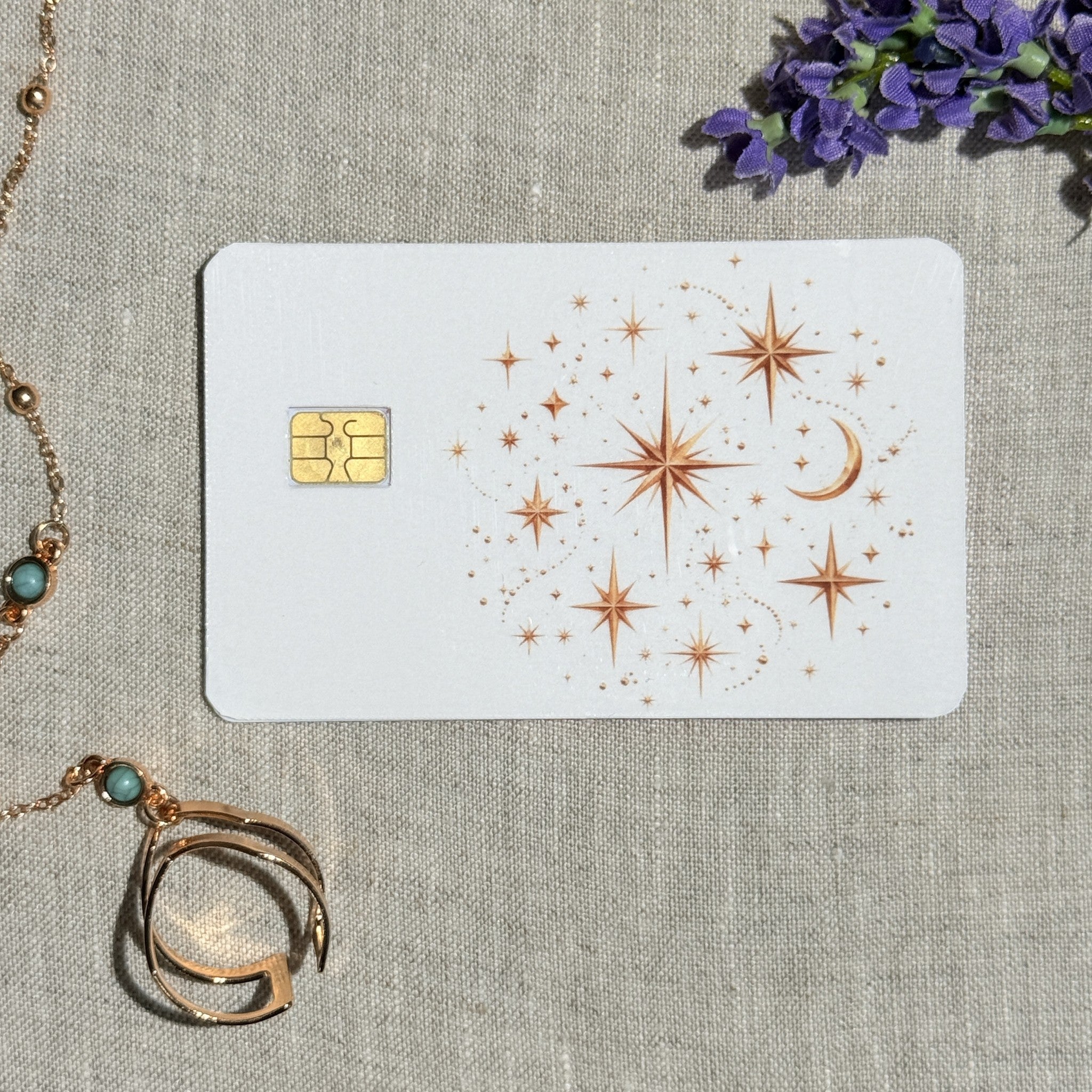 Celestial stars card skin on a debit card, copper stars and a crescent moon on white