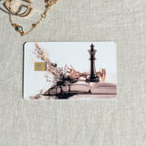 Chess king card skin on a debit card, black king on an open book dissolving into pieces