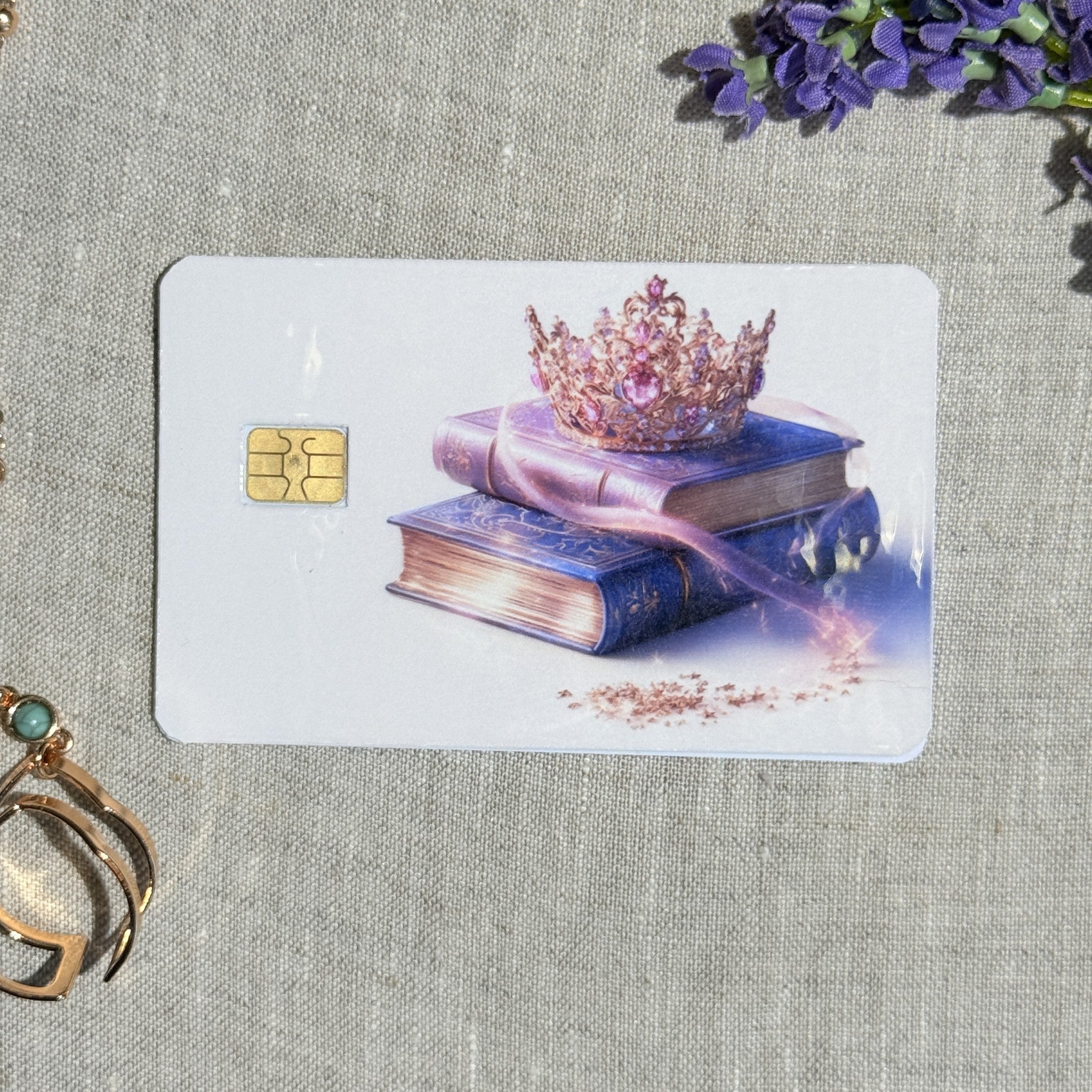 Pink jeweled crown debit card sticker shown flat on linen