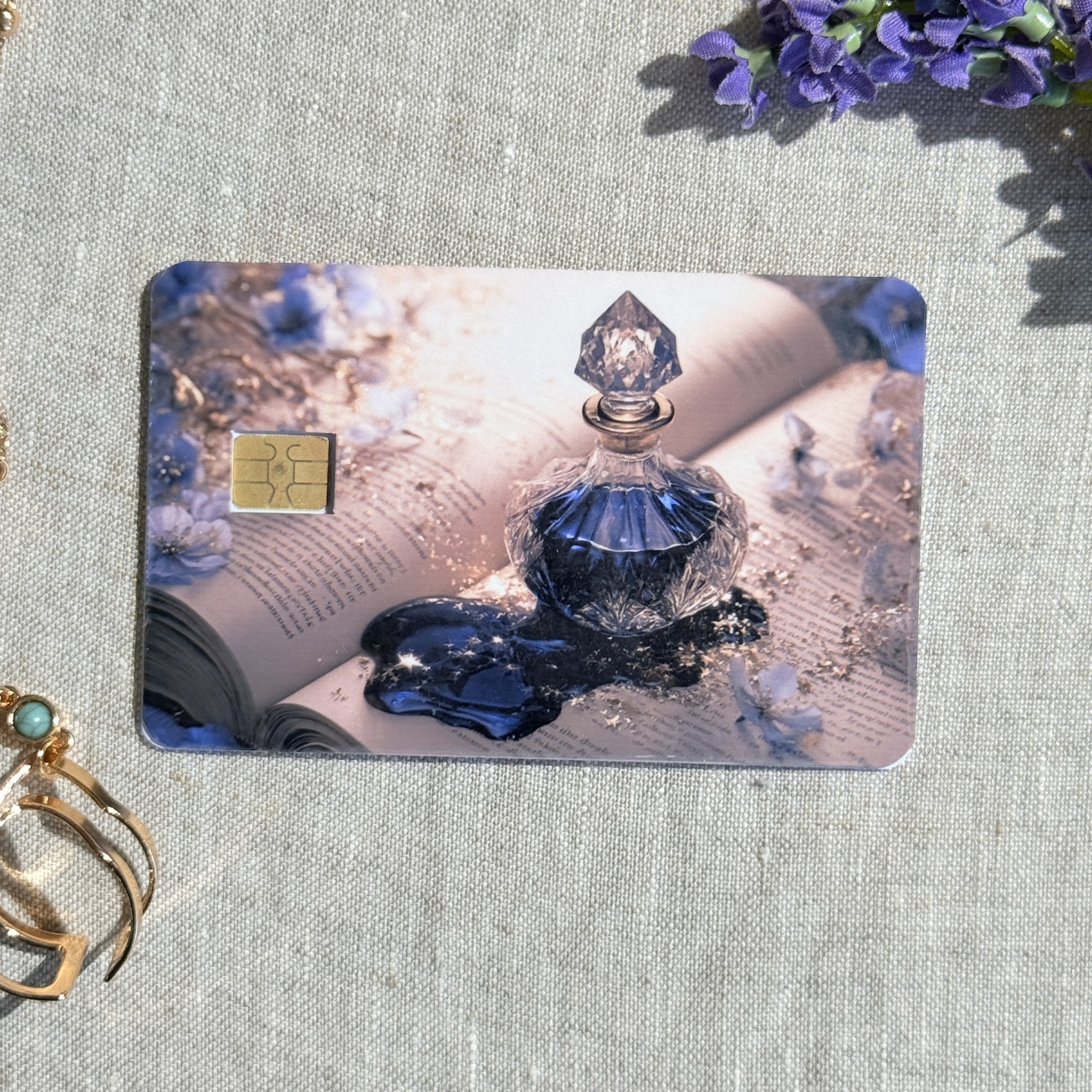 Blue bottle and open book debit card sticker shown flat on linen