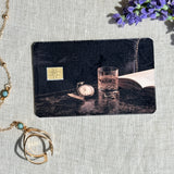 Dark academia pocket watch debit card sticker shown flat on linen
