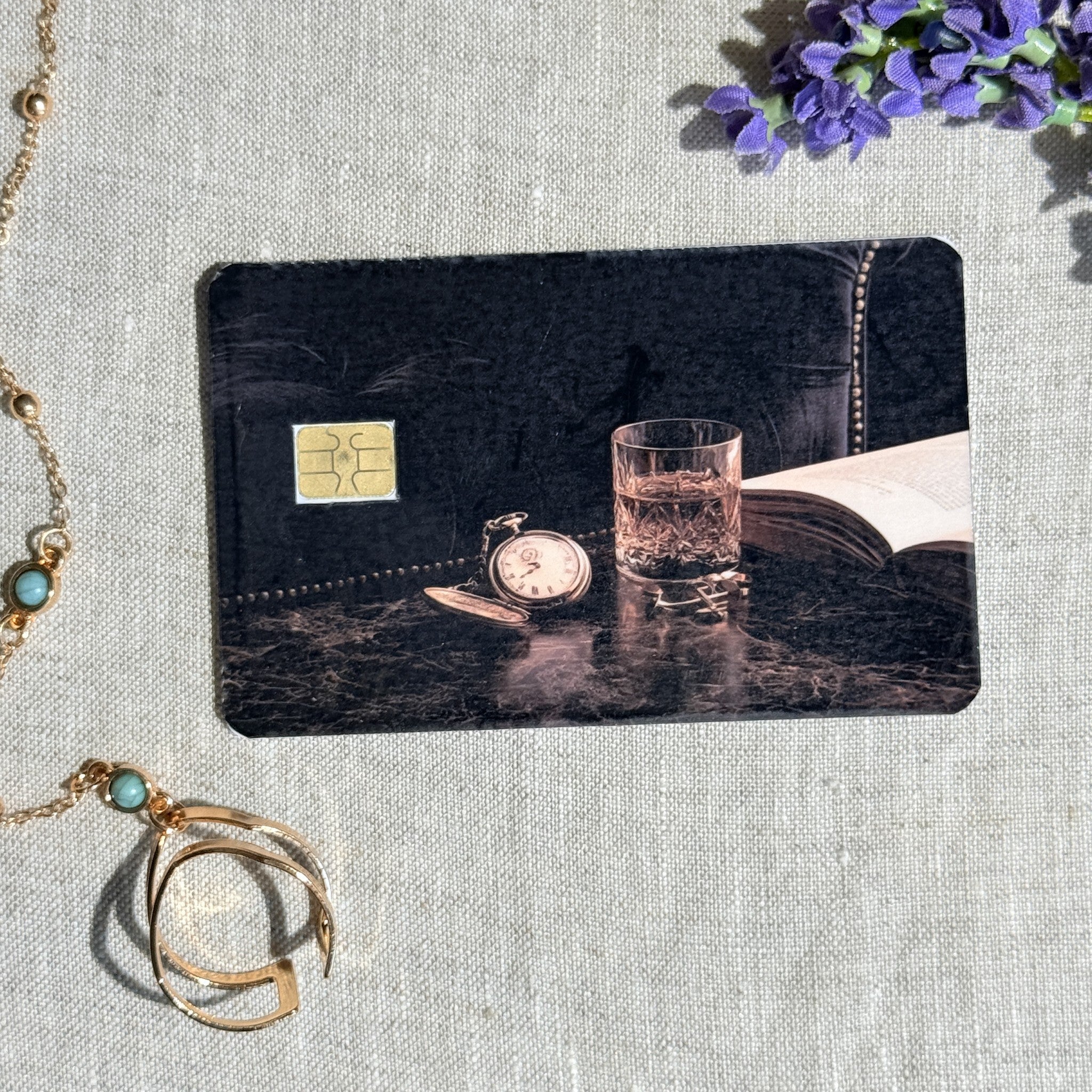 Dark academia pocket watch debit card sticker shown flat on linen
