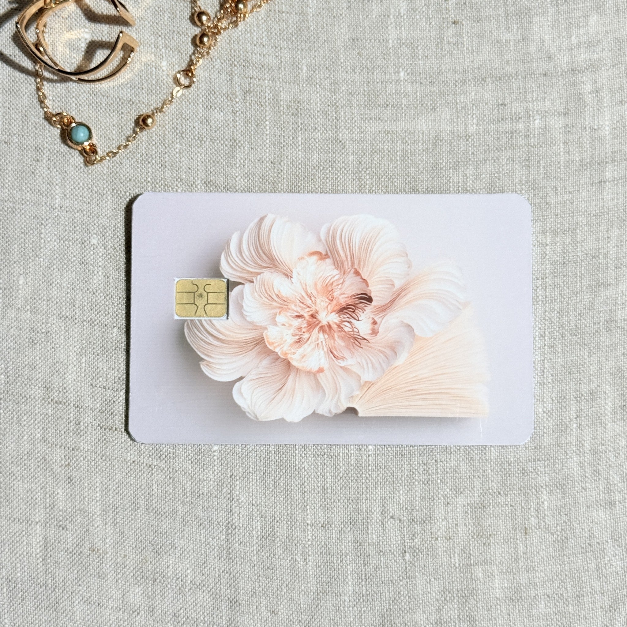 Soft blush bloom debit card sticker shown flat on linen
