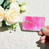Pink marble credit card sticker held up catching the light by The Sticker Era