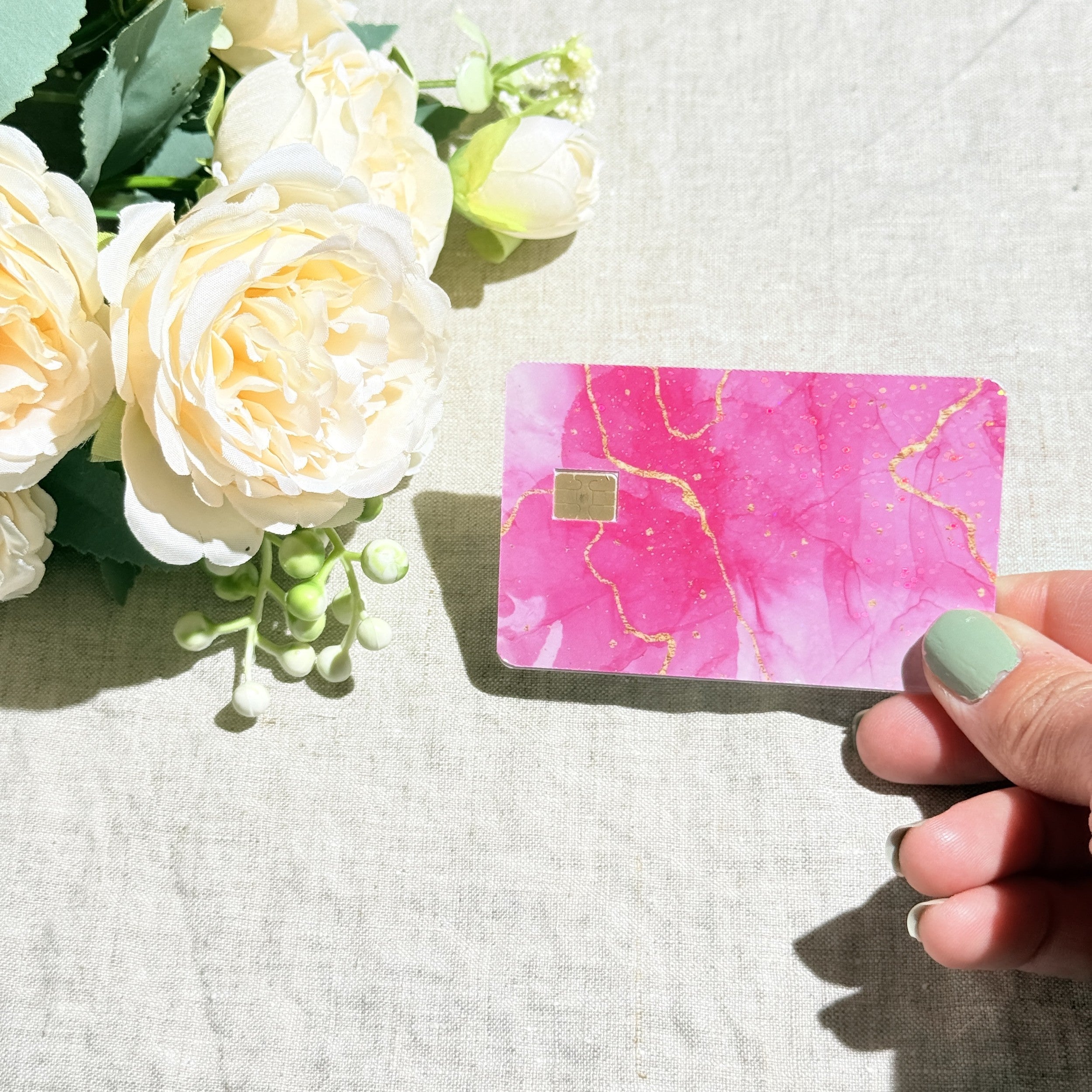 Pink marble credit card sticker held up catching the light by The Sticker Era
