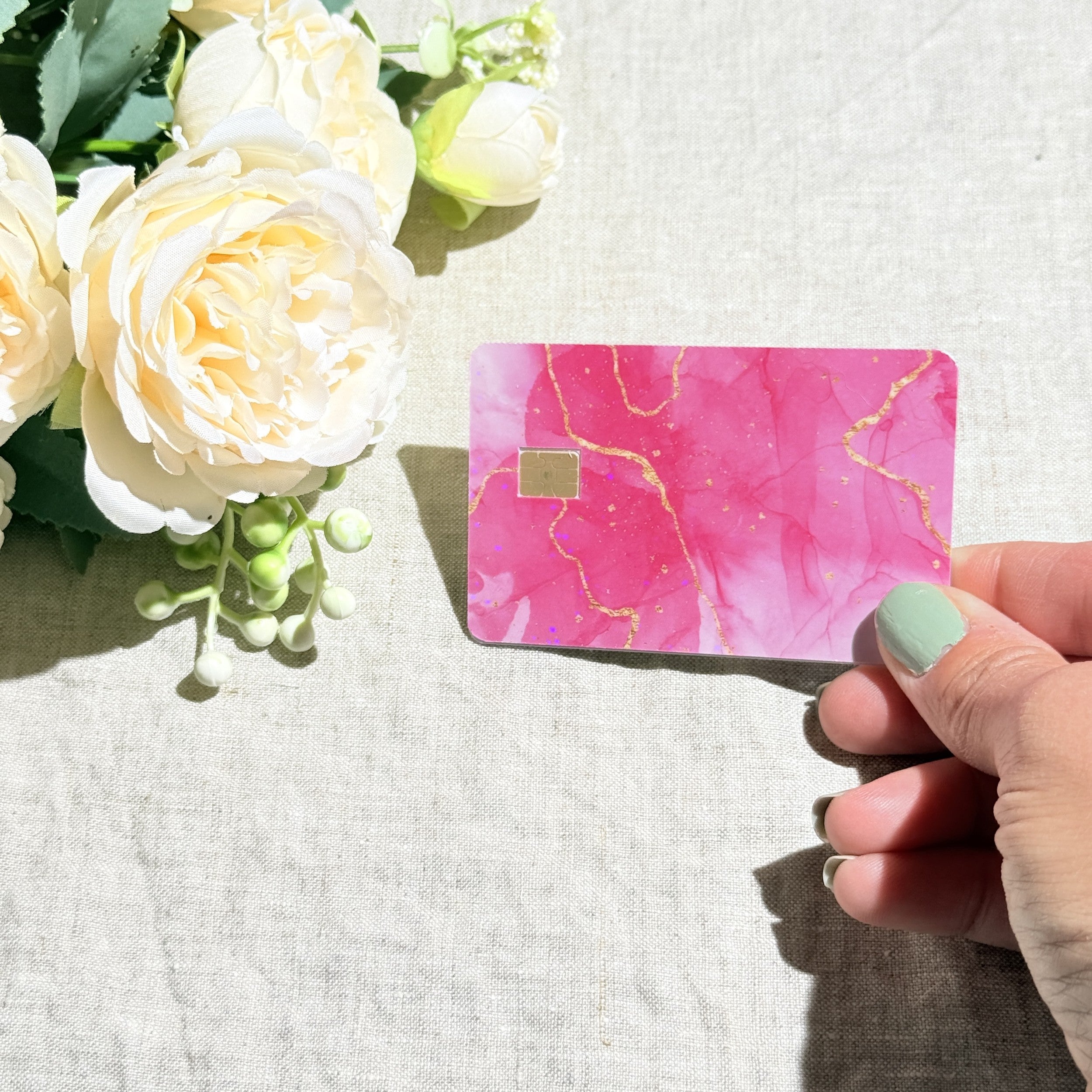 Pink marble card skin held at an angle by The Sticker Era