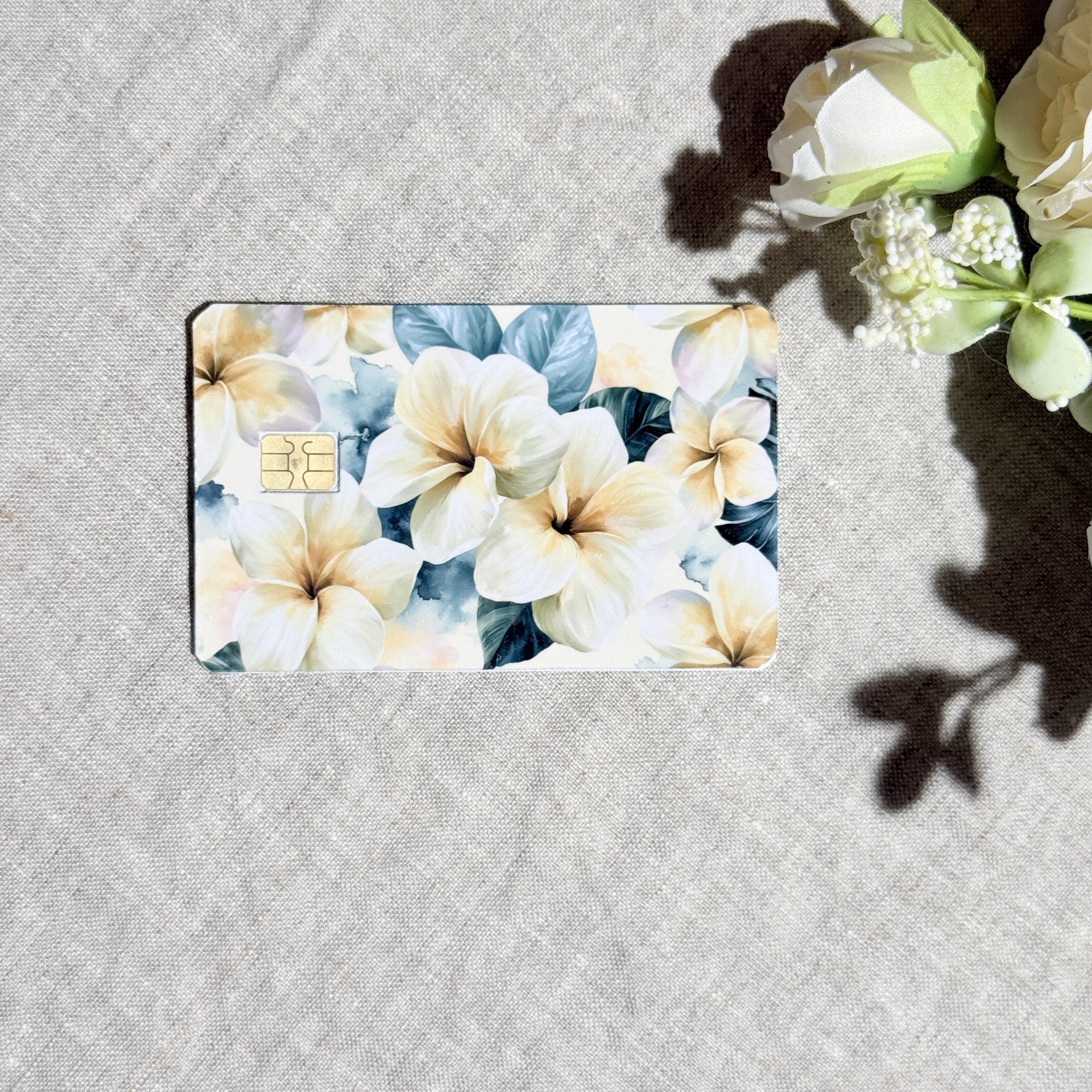 Plumeria floral card skin flat lay on cream linen by The Sticker Era