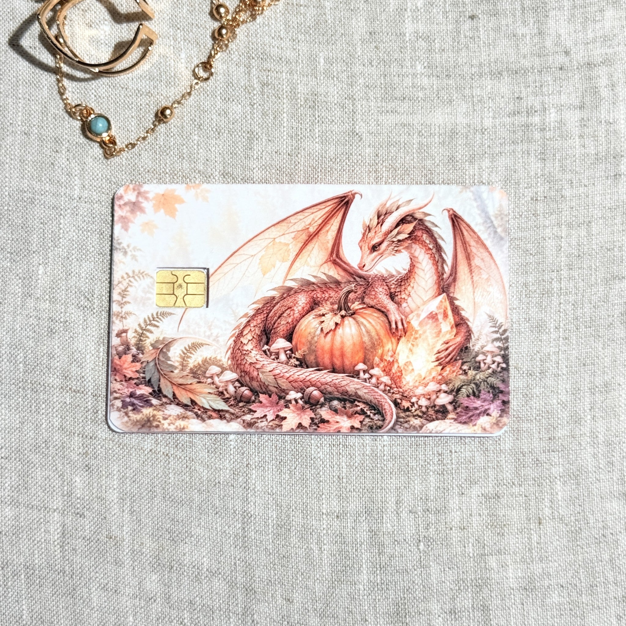 Cozy fall dragon debit card sticker shown flat on linen