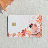 Cozy fall coffee debit card sticker shown flat on linen