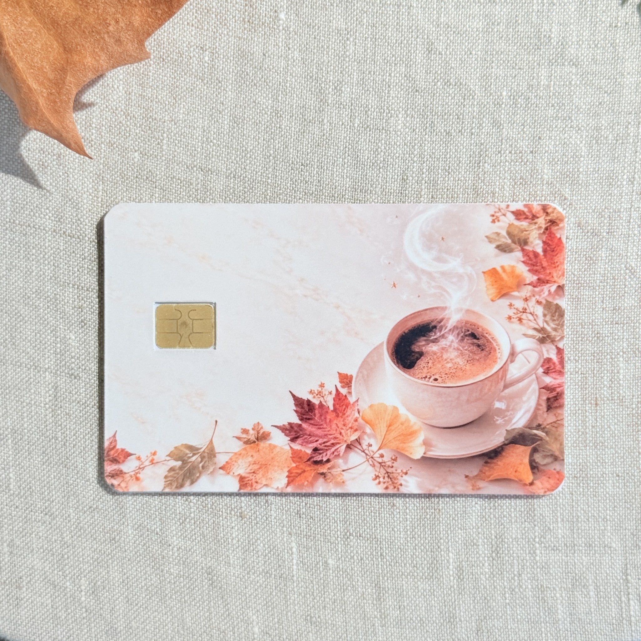 Cozy fall coffee debit card sticker shown flat on linen