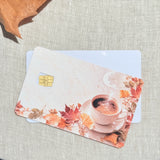 Two pumpkin spice latte card skins stacked to show the standard and sparkle finishes