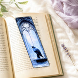 Raven bookmark resting on an open book by The Sticker Era