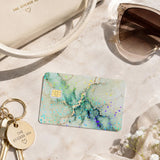 Green marble card skin flat lay with keys, sunglasses and a cream wallet by The Sticker Era