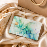 Green marble card skin standing on a windowsill in soft light by The Sticker Era