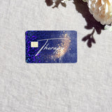 Therapy card skin with gold script and holographic sparkle on a navy galaxy debit card by The Sticker Era