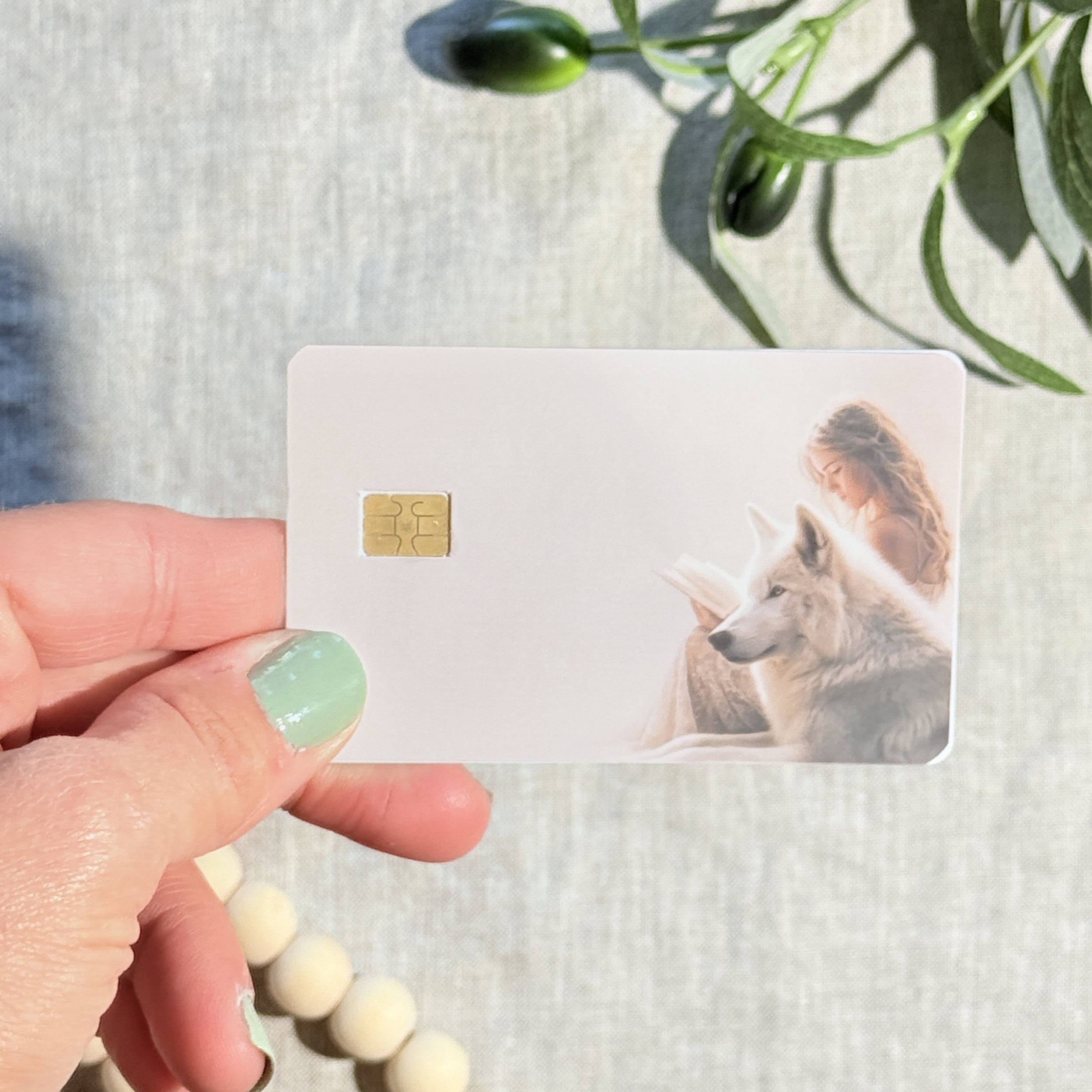 Cream white wolf reader debit card skin flat lay on linen by The Sticker Era