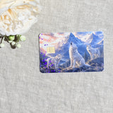 Wolf pack card skin with three white wolves howling under snowy mountains on a debit card by The Sticker Era