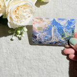 Hand holding the wolf pack debit card skin in sunlight by The Sticker Era