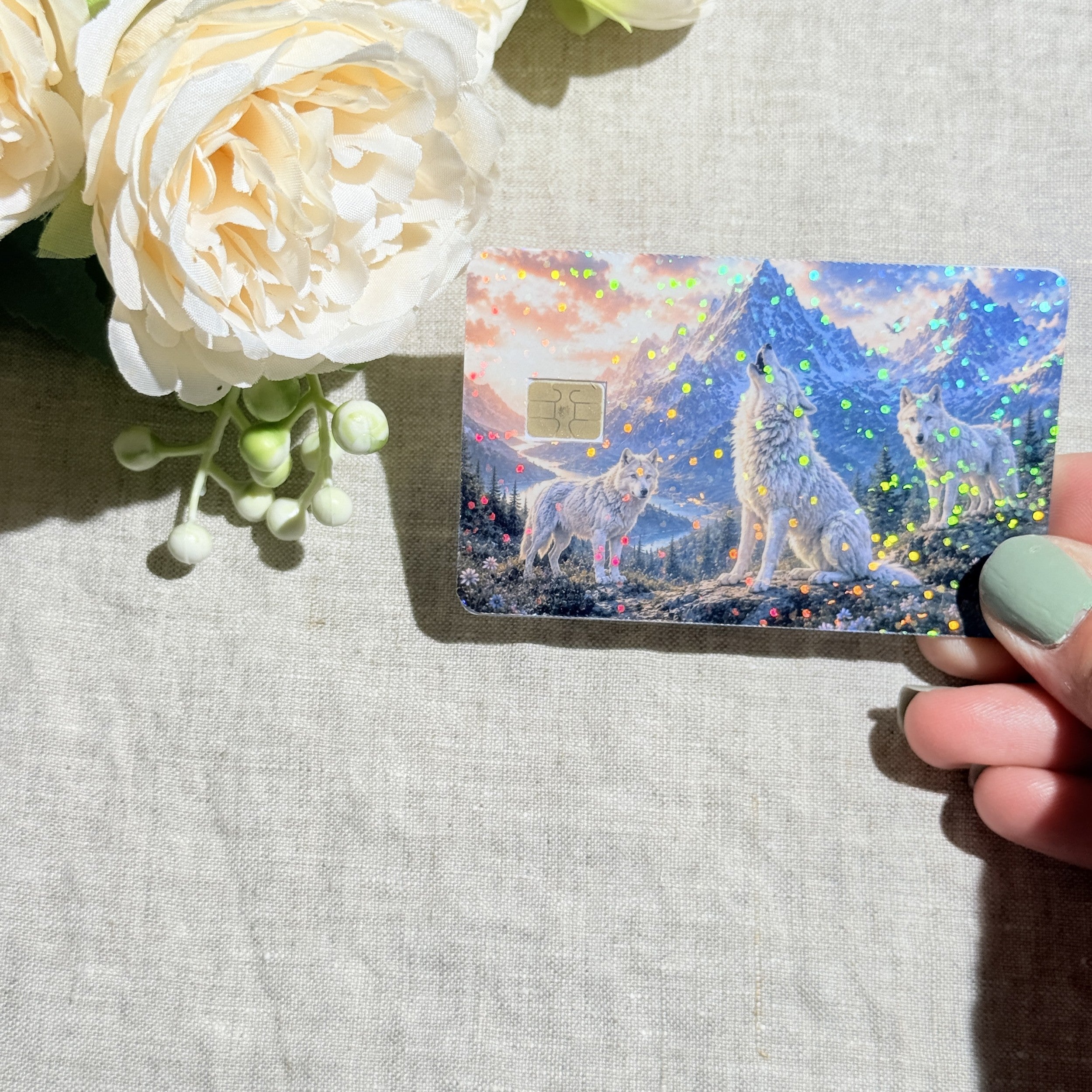 Hand holding the wolf pack debit card skin in sunlight by The Sticker Era