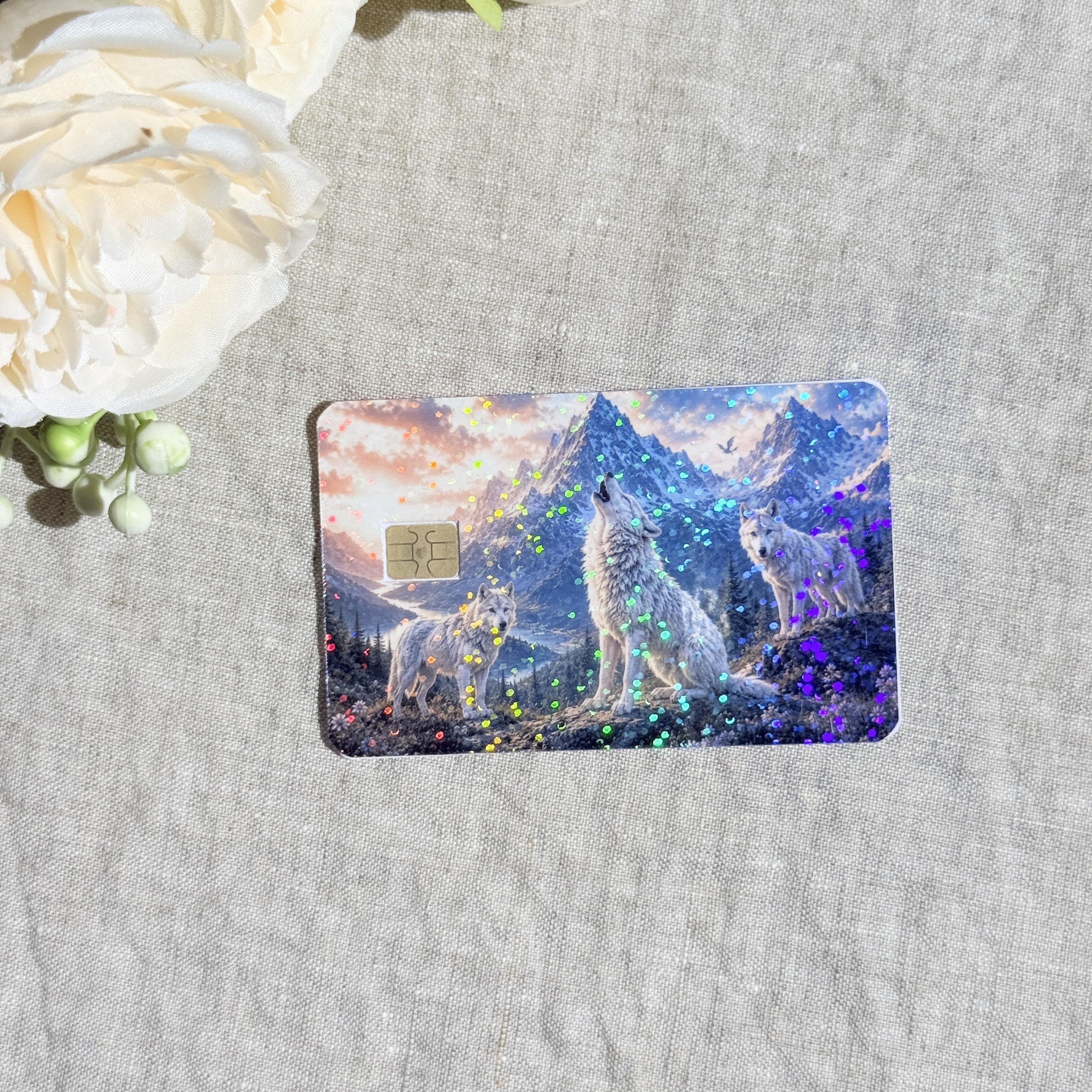 Close-up of holographic sparkle over the wolf pack and pink sunset sky on the card skin by The Sticker Era